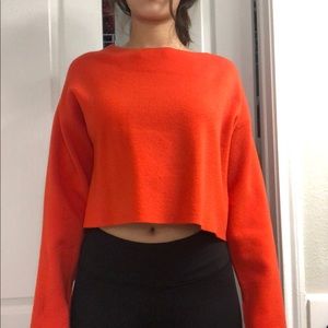 Bright red-orange sweater ties at the back